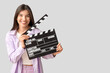 © Pixel-Shot - Young pretty woman with movie clapper on white background