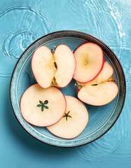 Wall Mural - Fresh a Apple slices floating in a clear blue water