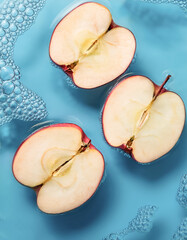 Wall Mural - Fresh a Apple slices floating in a clear blue water