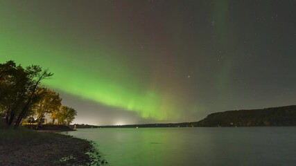 Wall Mural - Timelapse view of Aurora Borealis happening over the St. Croix River in USA. Natural phenomenon.