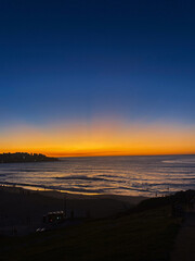 Bondi Beach, Australia at twilight, orange and blue sunset landscape of rolling waves on beach