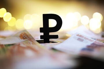 Wall Mural - Russian Ruble Currency Symbol with Blurred Banknotes and Gold Bokeh Lights in Background