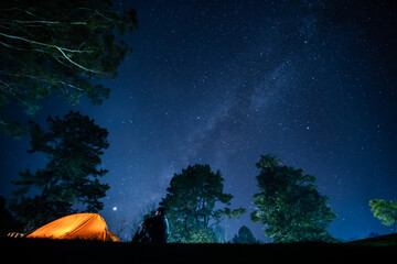 Wall Mural - nature traveling with orange camping tent on mountain with milky way background