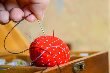 bright red pincushion shaped like a strawberry сraft tutorials sewing and DIY kits related tools creativity hobbies work educational basics beginner hands-on crafting atmosphere needles and threads