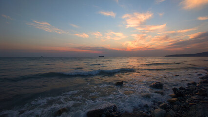 Poster - A peaceful scene of a sunset over the ocean with a boat in the distance, great for travel or nature-related concepts.