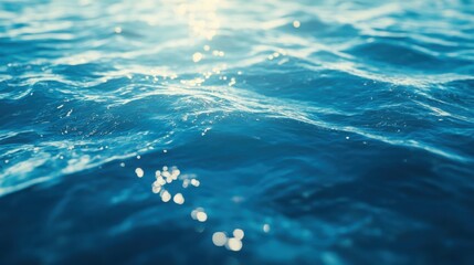 Wall Mural - Close-up of shimmering blue ocean waves reflecting sunlight.