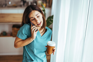 Wall Mural - Young Professional Woman Engaged in Phone Conversation with Coffee