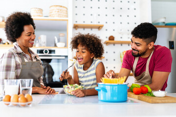 Wall Mural - happy african american family preparing healthy food in kitchen, having fun together on weekend