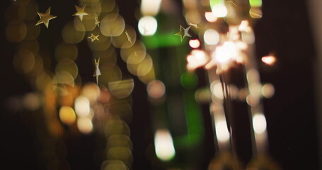 Poster - Sparkler glowing with golden star image over blurred festive lights background