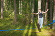 © Dmitry Naumov - Young girl practicing slacklining in a serene woodland