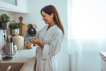 Wall Mural - Woman Enjoying Morning Coffee in a Cozy Kitchen Setting