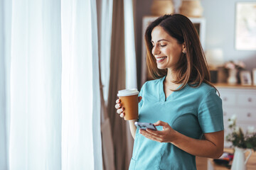 Wall Mural - Smiling Professional Woman Enjoying Coffee Break With Mobile Phone