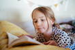 © Austockphoto - Young girl reading a book at home