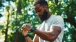 © Павел Озарчук - Man in park checking fitness watch expressing dissatisfaction after workout session on a sunny day