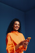 © Jacob Lund - Happy woman using mobile phone in bright, colorblocked monochromatic space, portraying modern creativity