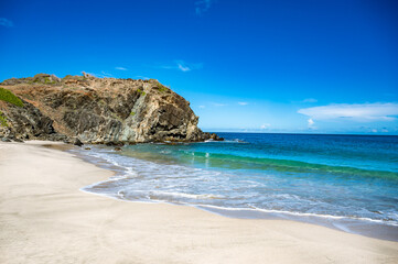 Wall Mural - A beautiful beach with a rocky cliff in the background