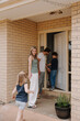 © Austockphoto - Family of four going into their house through front door
