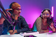 © BJ Day Stock - Two young asian streamer host making live podcast with condenser microphone and tablet at broadcast home studio. Content creator and social media influencer creating digital content.