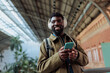 © bernardbodo - Tourist listening to music on his smart phone in a train station