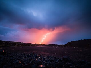 Poster - A lightning bolt strikes a mountain peak at night, casting a dramatic glow on the rugged terrain and illuminating rolling clouds through the stormy atmosphere