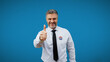 © Synthex🇺🇦 - Happy male politician shows a thumbs-up, isolated on a blue background during elections