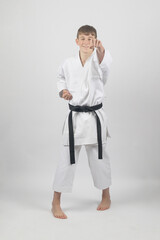 Fifteen year old male teenage karate black bel in sanchin stance punching , studio shot against a white background