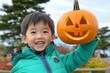 © Anna - Sweet child using a Halloween pumpkin as a mask for their Halloween outfit.