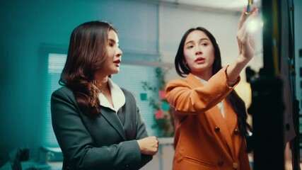 Aufkleber - Two businesswomen engage in a discussion within an office setting, utilizing a whiteboard to brainstorm and refine ideas for an upcoming project. Collaboration and strategy take center stage