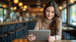 © Oleksandr - woman with a tablet in a cafe working remotely