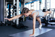 © ty - Portrait of a muscular woman on a plank position at gym.