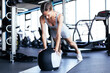 © ty - Fit and muscular woman exercising with medicine ball at gym.