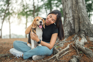 happy asian woman playing with dog together in public park outdoors, friendship between human and th