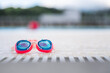 © ADDICTIVE STOCK - Vivid poolside goggles resting on a sunlit outdoor deck