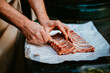 © Melissa Milis Photography/Stocksy - chef prepares pork ribs for cooking with precision and care