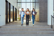 © Manu Padilla/Stocksy - Happy college classmates with notebooks walking downstairs