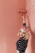© Melika Tursic/Stocksy - Woman painting pink wall at home