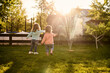© Iuliia Versta/Stocksy - two small children playing on the grass in the backyard