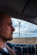 © tessy morelli/Stocksy - Driving in the countryside with wind turbine
