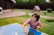 © Natalia Mishina/Stocksy - Young child playing table tennis.