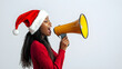 © Flux Imagery - Mujer negra grita a un megáfono con un gorro de Papá Noel con fondo blanco