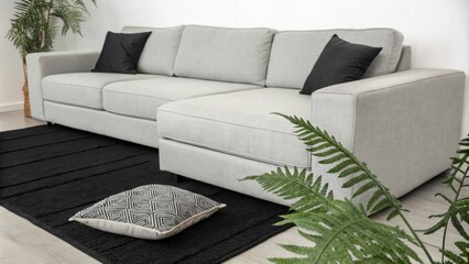 Aufkleber - A cleanlined modular couch in shades of gray complements the monochrome theme of the space. A striking black rug anchors the seating area while a leafy fern adds a subtle pop