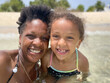 © Anya Brewley Schultheiss/Stocksy - Happy portrait of mother and child smiling happily while in the ocean