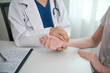 © Treerat - A doctor is examining a patient's hand
