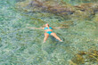 © Dmitri - A girl in a swimsuit floats on her back in the azure sea in the south of France on a summer day.