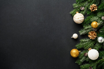 Christmas decorations and spruce tree at black background. Flat lay with copy space.