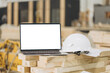 © anatoliycherkas - Laptop showing mockup screen with white hard hat in modular building industry