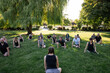 © Rob and Julia Campbell/Stocksy - Group Yoga Class in a Sunny Park Setting