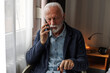 © Jovo Jovanovic/Stocksy - Elderly man talking on cellphone at home