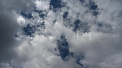 Wall Mural - time lapse looking up into puffy white cloud churning in a dark blue sky