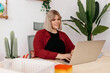 © Tania Cervian/Stocksy - Cheerful curvy lady typing on laptop in office